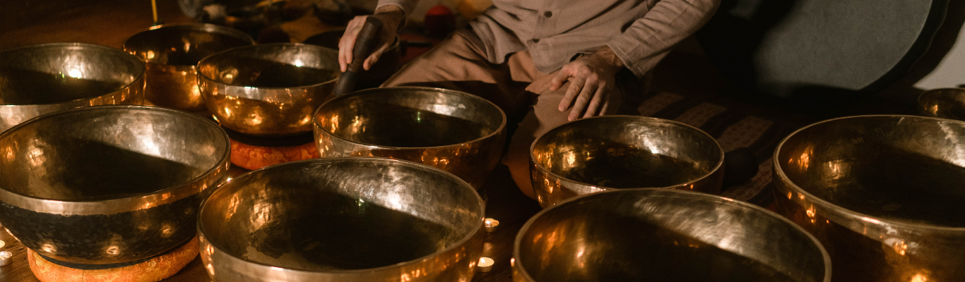 Uomo che suona campane tibetane rilasciando armonici nell'aria