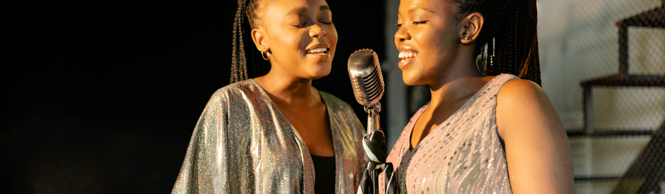 Due ragazze afroamericane cantano nello stesso microfono